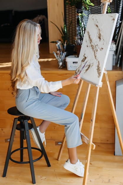 Mujer joven artista pintando en casa pintura creativa vista posterior