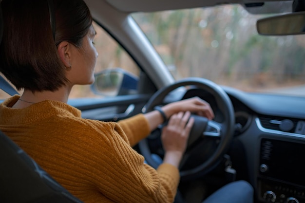 Mujer joven asiática al volante de un coche