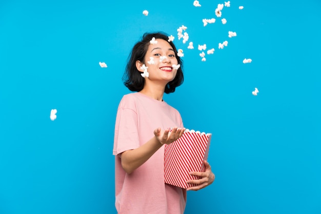 Mujer joven asiática comiendo palomitas de maíz