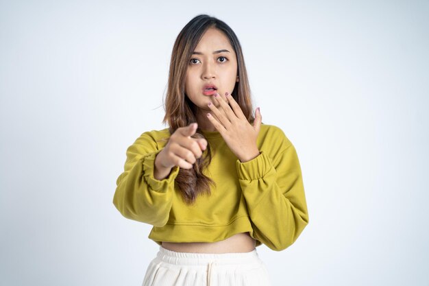 Mujer joven asiática con el gesto de la mano que señala con el dedo