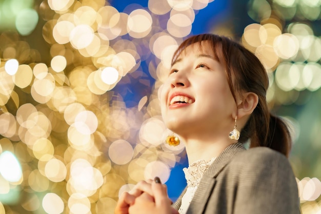 Mujer joven asiática que disfruta de las iluminaciones en la ciudad