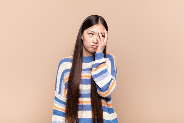 Mujer joven asiática que se siente aburrida, frustrada y con sueño después de un cansado