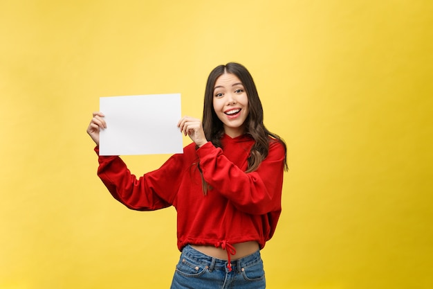 Mujer joven asiática que sostiene el tablero o el papel en blanco.