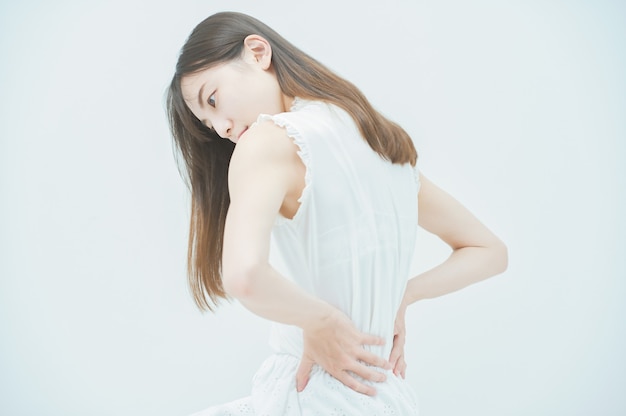Mujer joven asiática que sufre de dolor de espalda