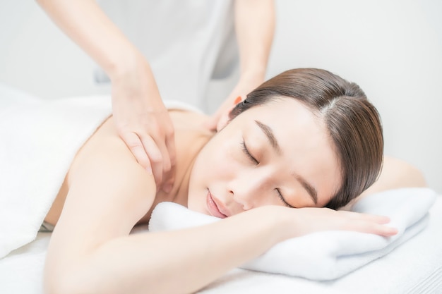 Mujer joven asiática recibiendo un masaje en un salón de estética