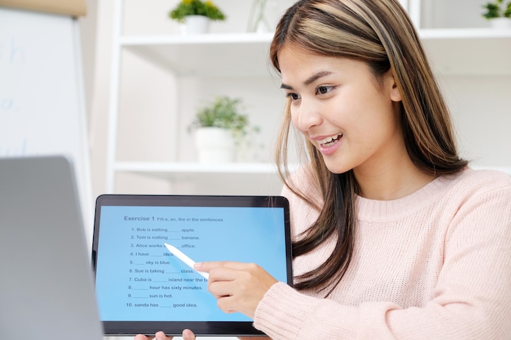 Foto mujer joven asiática con una tableta digital mientras enseña inglés en clase en línea