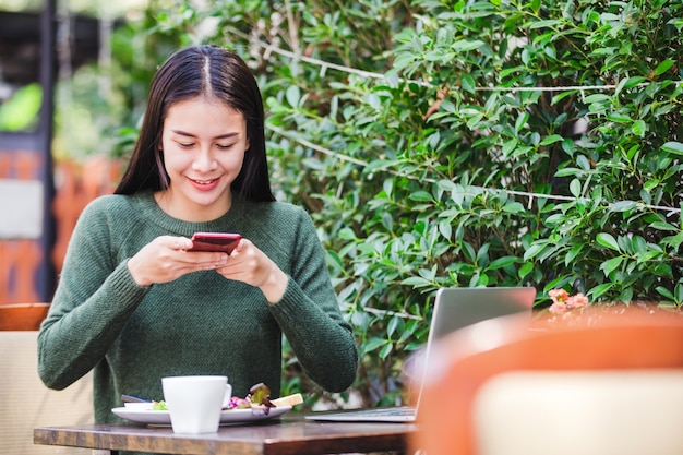 Mujer joven asiática tomando una foto de desayuno