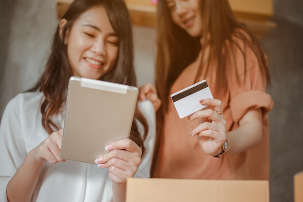 Mujer joven asiática trabaja desde casa marketing online actualmente ordenando productos para la venta y entrega para el cliente. Propietario de negocio, PYME, envío, trabajo desde casa (FMH), autónomo, concepto de puesta en marcha.