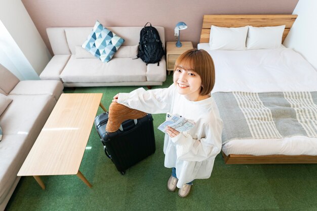 Mujer joven asiática con vistas a la habitación del hotel