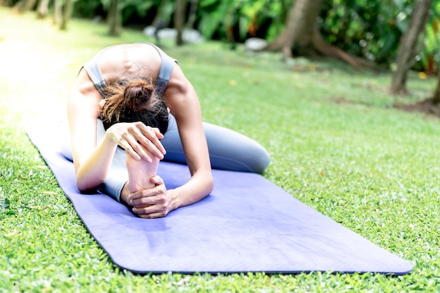 Mujer joven atractiva asiática tiene un cuerpo hermoso jugando yoga en una postura elegante