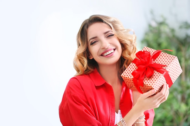 Mujer joven atractiva con caja de regalo en el interior