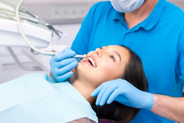 Mujer joven atractiva en una clínica dental con un dentista masculino. Concepto de dientes sanos.