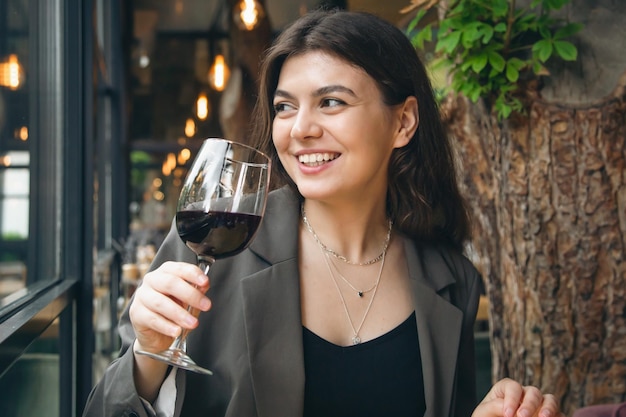 Mujer joven atractiva con una copa de vino en un restaurante