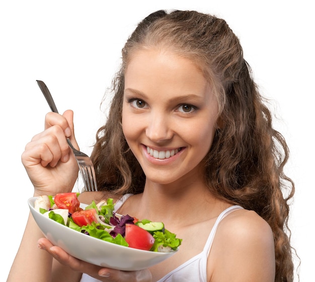 Mujer joven atractiva disfrutando de verduras frescas en el desayuno