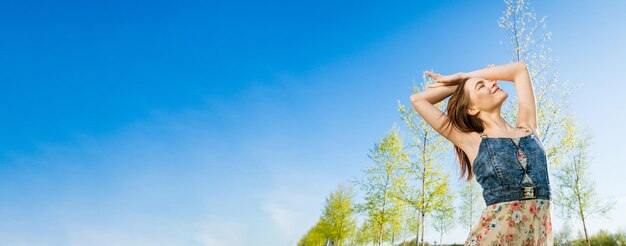 Foto mujer joven atractiva y feliz vestido largo de flores volando su cabello disfrutando libremente