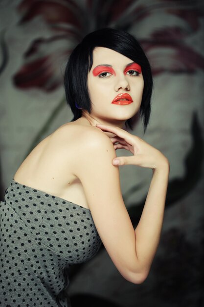 Mujer joven atractiva con maquillaje rojo brillante