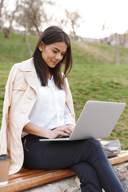 Foto mujer joven atractiva con ordenador portátil