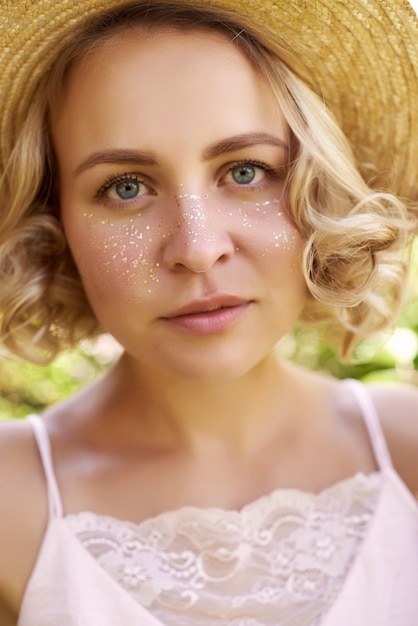 Foto mujer joven atractiva con las pecas de oro que disfruta de su tiempo afuera en parque con puesta del sol en fondo.