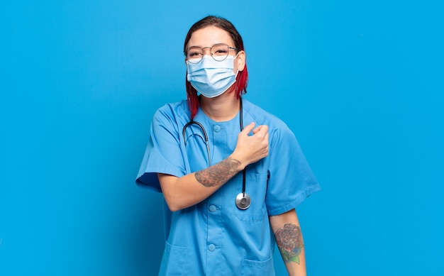 Mujer joven atractiva pelirroja que se siente feliz, positiva y exitosa, motivada cuando se enfrenta a un desafío o celebra buenos resultados. concepto de enfermera del hospital