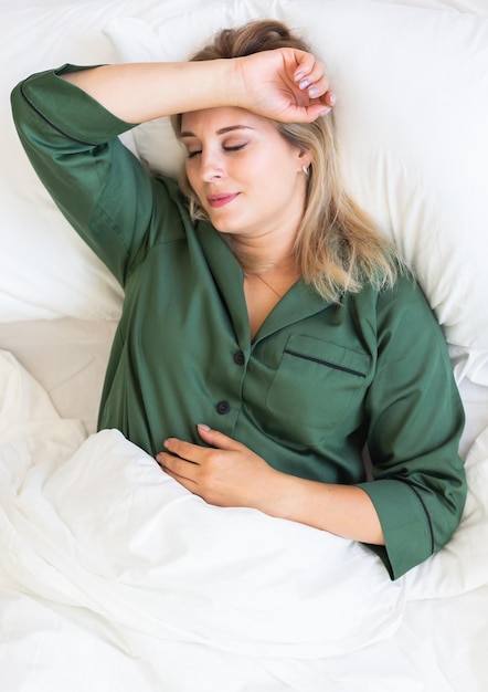 Mujer joven atractiva en pijama dormir en la cama