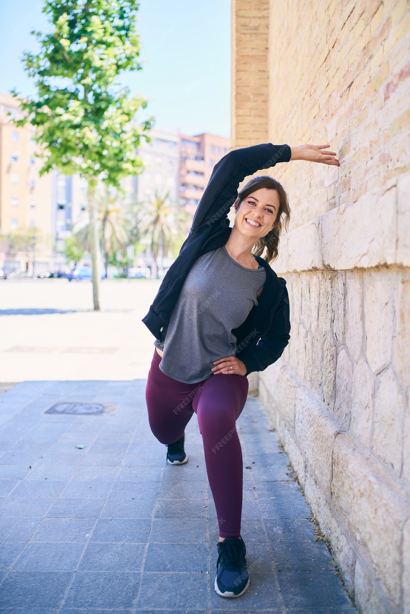 marido Desobediencia buscar Mujer joven atractiva que hace ejercicios de estiramiento delante de la  pared de ladrillo. ubicación urbana. modelo de fitness ejercicio, ropa  deportiva y sudadera con capucha negra. estiramiento de piernas y brazos. |  Foto Premium