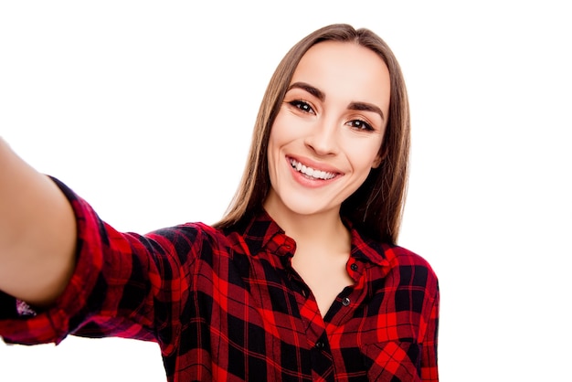 Mujer joven atractiva con sonrisa radiante haciendo selfie