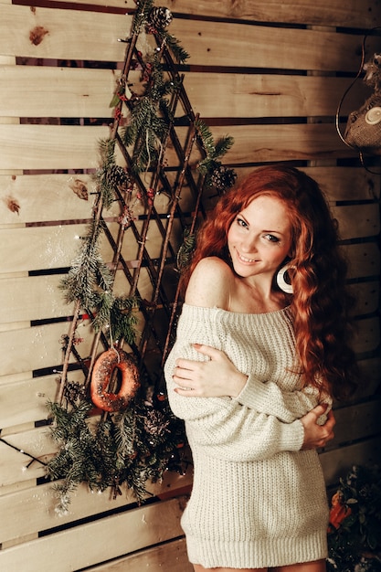 Mujer joven atractiva en un tiro de moda de invierno vistiendo un suéter de lana blanco y calcetines de punto