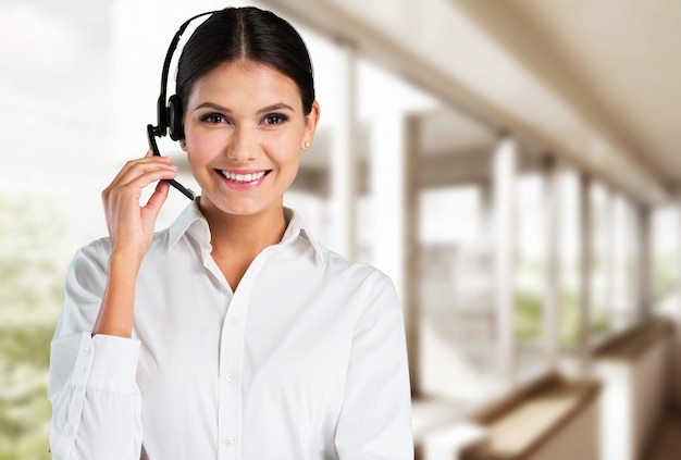 Mujer joven con auriculares, call center o