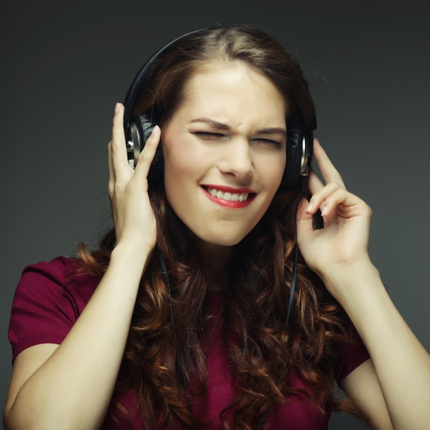 Mujer joven con auriculares escuchando música