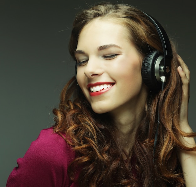 Mujer joven con auriculares escuchando música