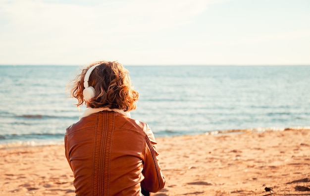 Mujer joven, en, un, auriculares, en la playa