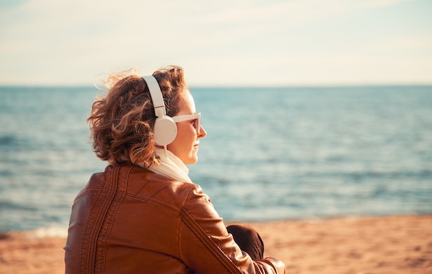 Mujer joven, en, un, auriculares, en la playa
