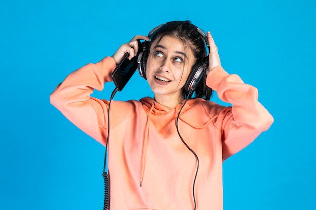 Mujer joven con auriculares y sosteniendo el teléfono Foto de alta calidad