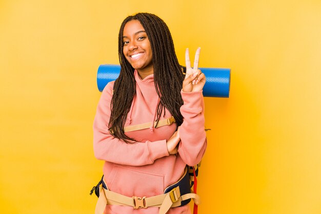 Mujer joven del backpacker del afroamericano que muestra el número dos con los dedos.