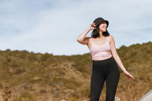 Mujer joven bailando en la cima de la montaña