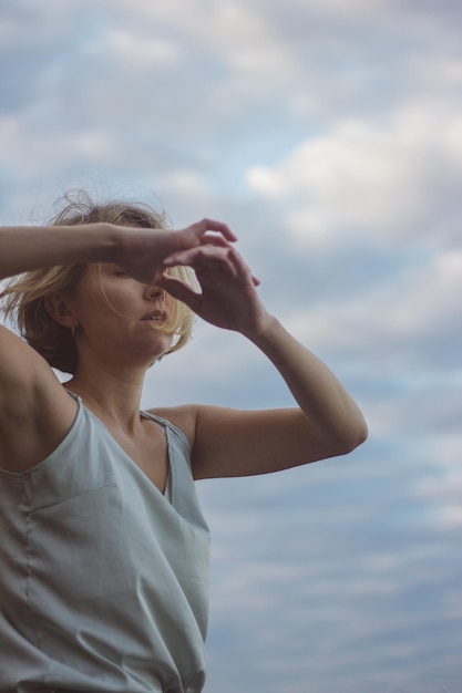 Foto mujer joven bailando contra el cielo nublado