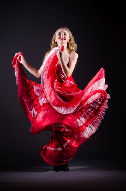 Mujer joven bailando en vestido rojo