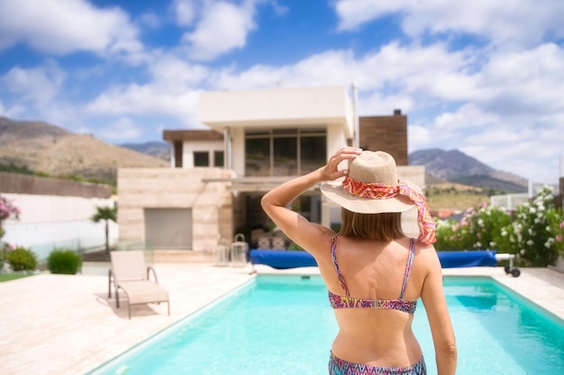 mujer joven bañándose en una piscina, en verano