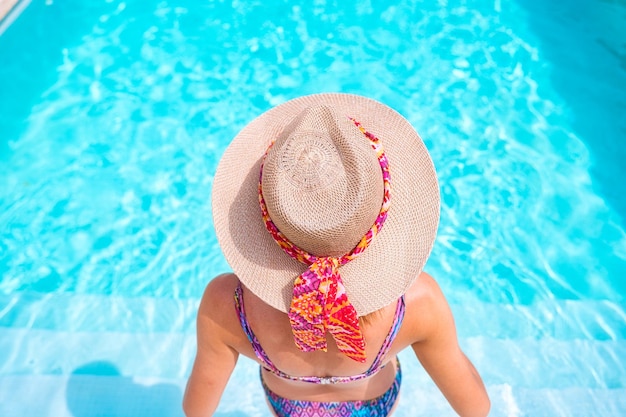 mujer joven bañándose en una piscina, en verano