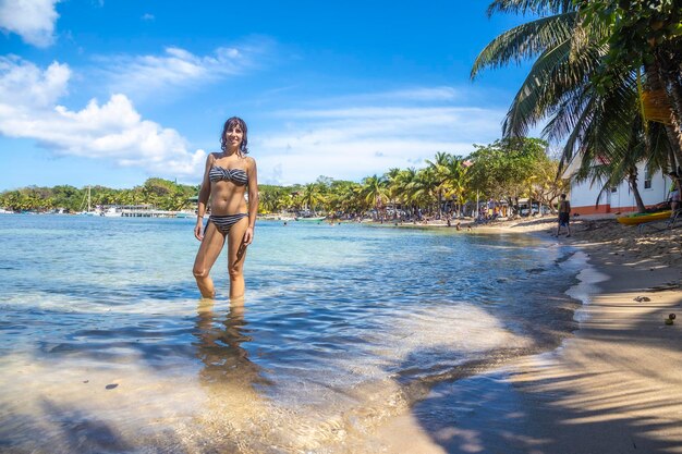 Una mujer joven bañándose en la playa en West End en la isla de Roatán Honduras