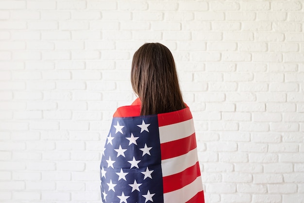 Mujer joven con bandera nacional de los Estados Unidos