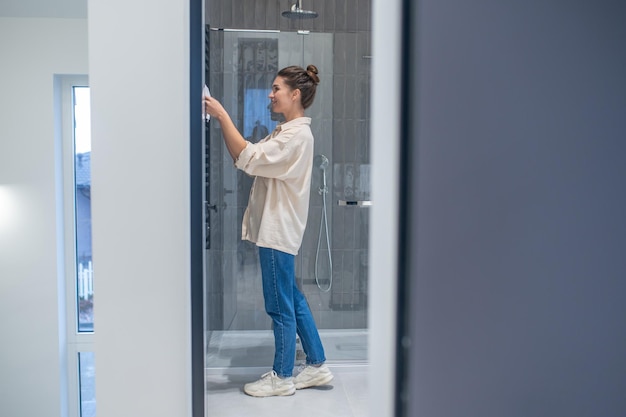 Mujer joven en el baño haciendo algo de limpieza