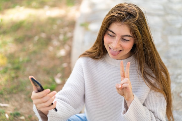 Mujer joven bastante caucásica usando teléfono móvil