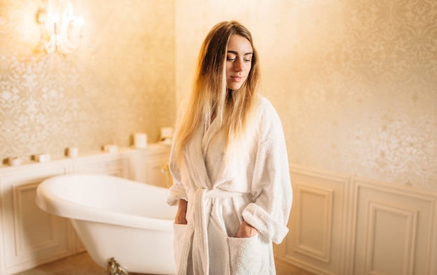 Mujer joven en bata de baño blanca