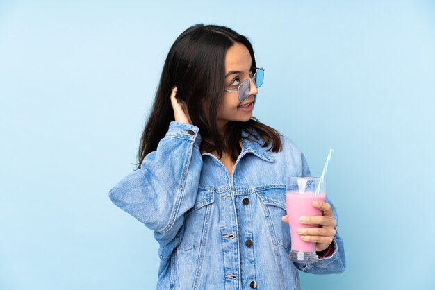 Mujer joven con batido de fresa aislado