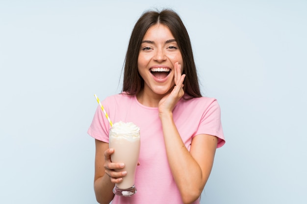 Mujer joven con batido de fresa con sorpresa y expresión facial conmocionada