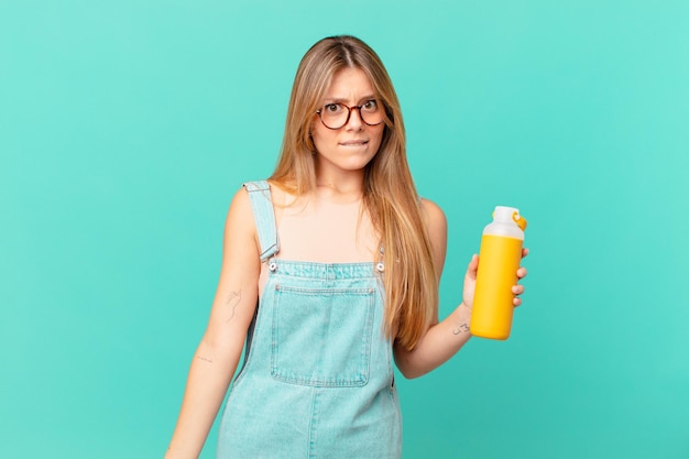 Mujer joven con un batido mirando perplejo y confundido