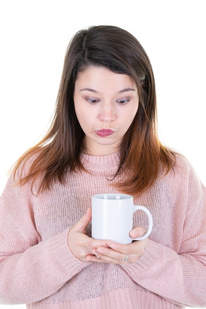 mujer joven, bebida, taza de café, encima, aislado, fondo blanco, serio, diversión, cara, pensamiento