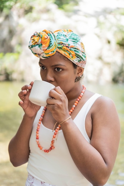 Mujer joven bebiendo café en el bosque