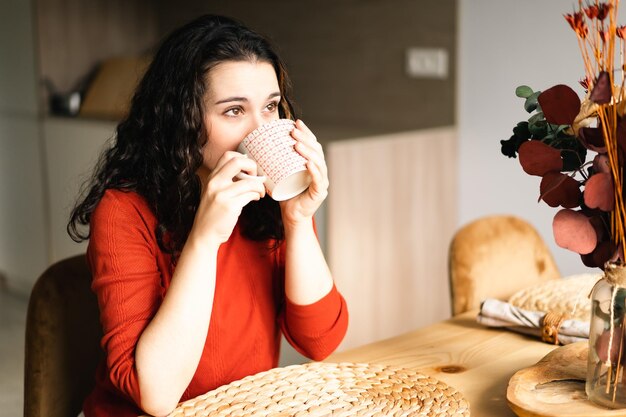 Foto mujer joven bebiendo café en casa